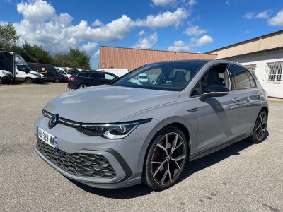 une voiture grise garée dans un parking à côté d'un bâtiment
