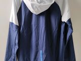 the back of a blue and white jacket hanging on a hanger