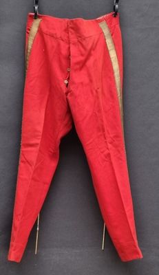 un vieux pantalon rouge accroché à un mur noir