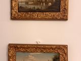 deux tableaux accrochés au mur d'un immeuble, avec une rivière en arrière-plan