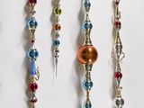 a lot of different colored beads hanging on the wall