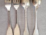 quatre cuillères en argent et deux cuillères en argent sur une table