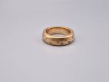 a close up of a gold ring on a white surface
