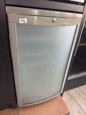 a refrigerator with a glass door in the middle of a kitchen
