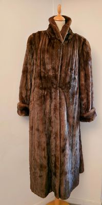 un manteau de fourrure posé sur un mannequin devant une lampe