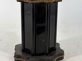 an image of a black and gold pedestal with a bird on top