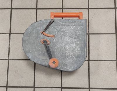 a small piece of metal on the floor next to a pair of scissors