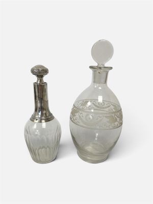 une bouteille en verre et une bouteille argentée sur fond blanc