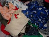 a pile of clothes that is sitting on a bed