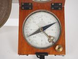 a clock that is hanging on the wall with a compass on it