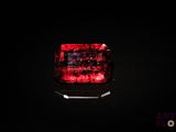 un gros plan d'une lumière rouge sur une surface noire