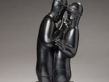 a black sculpture of a man and a woman hugging each other