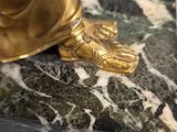 a gold statue of a person on a marble base