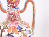 a vase with a handle that has a floral design on it