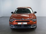 the orange car is parked in a white room with a black floor