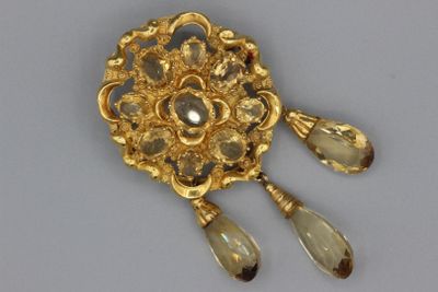 une image représentant une broche en or avec deux larmes et deux larmes