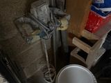 un seau de peinture posé à côté des toilettes dans une pièce
