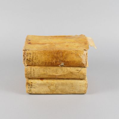 trois vieux livres empilés les uns sur les autres sur une table