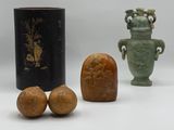 trois vases et deux noix posés sur une surface blanche, sur fond gris