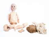 une petite poupée assise à côté d'une peluche