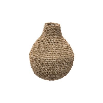 un vase tressé posé sur une surface blanche