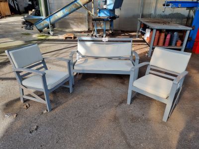 three chairs and a table in front of a building