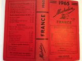 an old book with a red cover sitting on top of a table