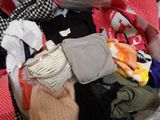 une valise remplie de vêtements, tous entassés les uns sur les autres