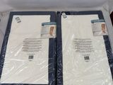 two white sheets are wrapped in plastic on top of a bed