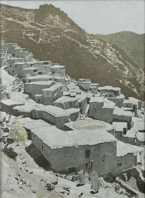 a black and white photo of a village in the mountains