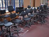 rows of black office chairs in a room with a large window