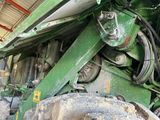 a close up of a large green tractor in a building