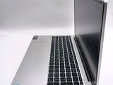 a silver laptop with a black keyboard on a white surface