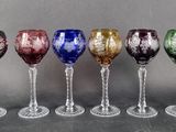 several different colored wine glasses are lined up in a row