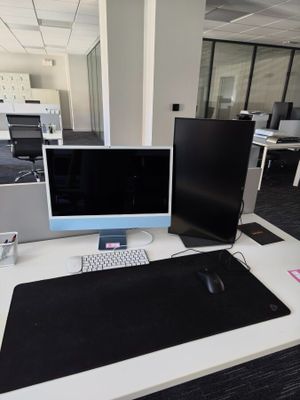 a desk with two monitors and a keyboard on it