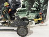 two toy soldiers that are standing next to a toy gun