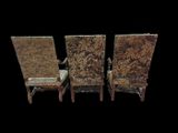three antique chairs with floral upholstered seats against a black background