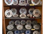 de nombreuses assiettes posées sur une étagère dans un placard