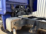 un semi-remorque bleu garé devant un immeuble