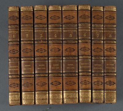 un coffret de douze livres reliés en cuir marron avec des couvertures dorées