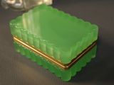 a green box sitting on a table next to a glass vase