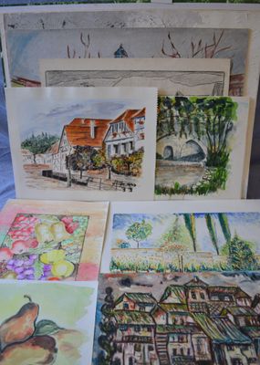 many cards that are on a table with a picture of a house in the background