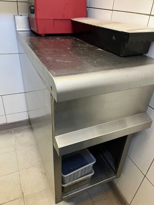 un comptoir en métal surmonté d'une poubelle rouge