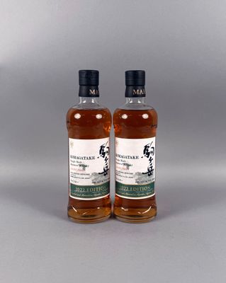 deux bouteilles de whisky posées l'une à côté de l'autre sur une table
