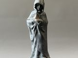 une statue représentant une personne portant une capuche