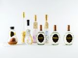 des bouteilles de différentes sortes d'alcool alignées sur une surface blanche