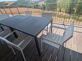une table et des chaises sur un balcon avec vue sur les montagnes