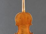 an old violin on a stand against a gray background