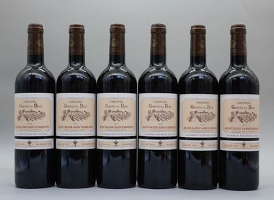 six bouteilles de vin sont alignées sur une table