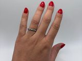 woman ' s hand with red manicured nails and a silver ring